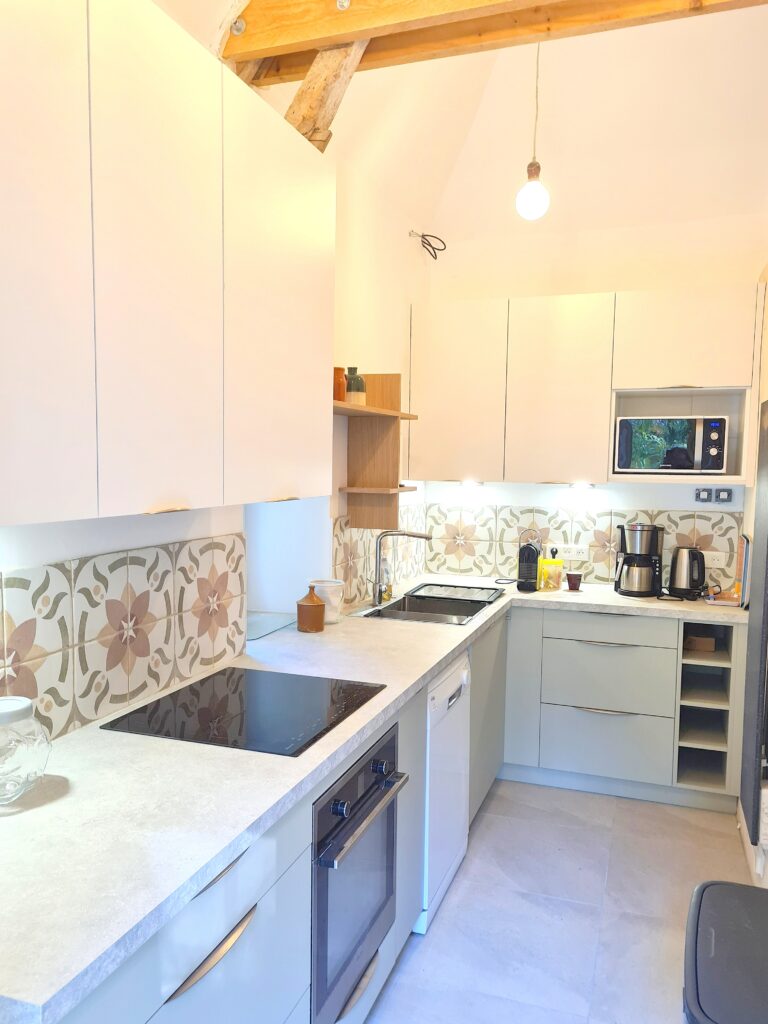 Cuisine de la Gourmandière avec meuble bas teinte sauge et meubles haut blanc craie